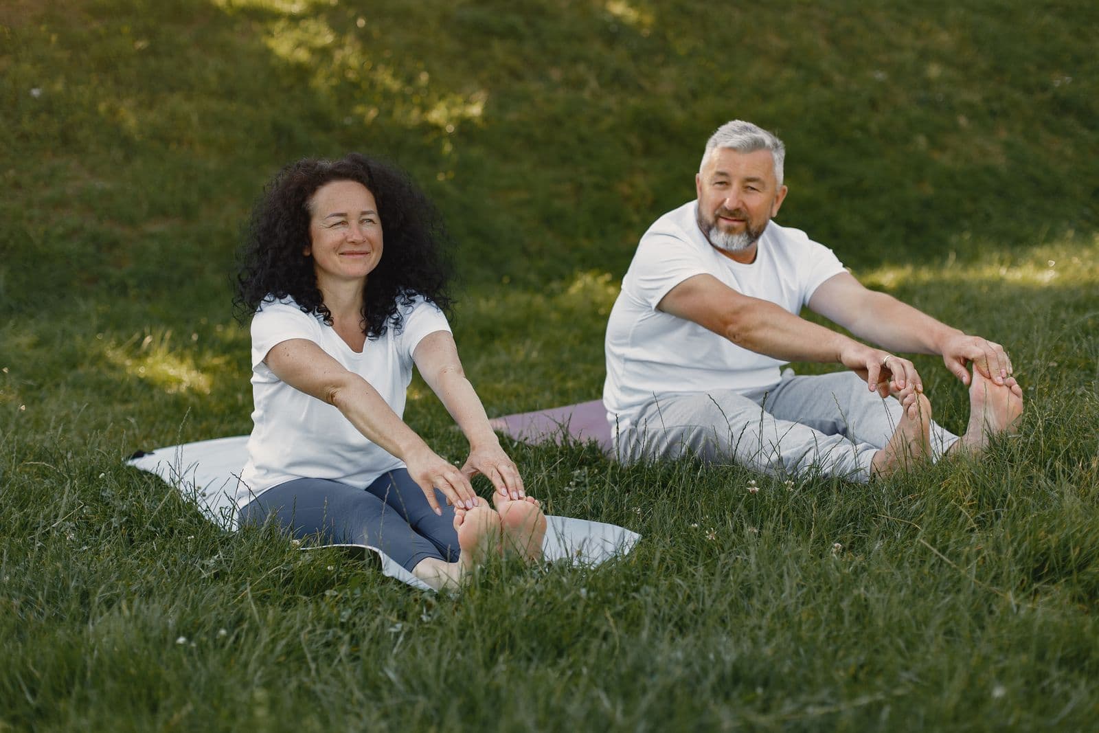 Two people stretching together outdoors